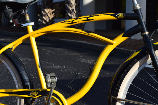 A close-up of a Mike's Hard Lemonade logo on a black and yellow 26 inch beach cruiser.