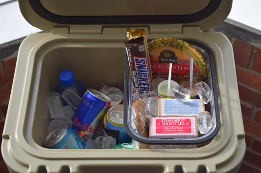 Cooler filled with ice and a variety of snacks and beverages